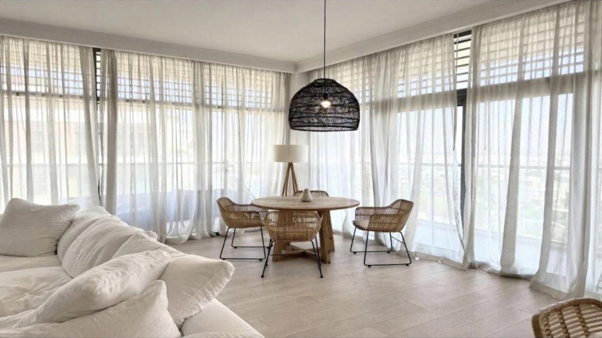 Furnished living room with white sofa and decor in Dubai Hills Estate apartment for rent