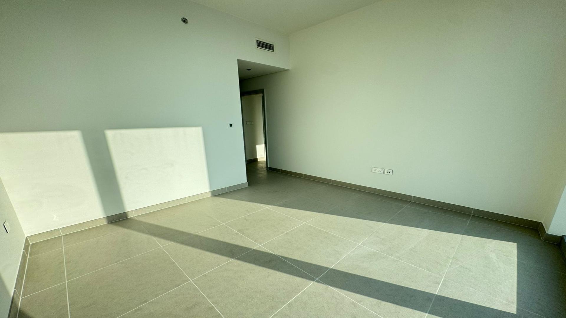 Empty room with large window view in Creek Beach apartment, Dubai Creek Harbour