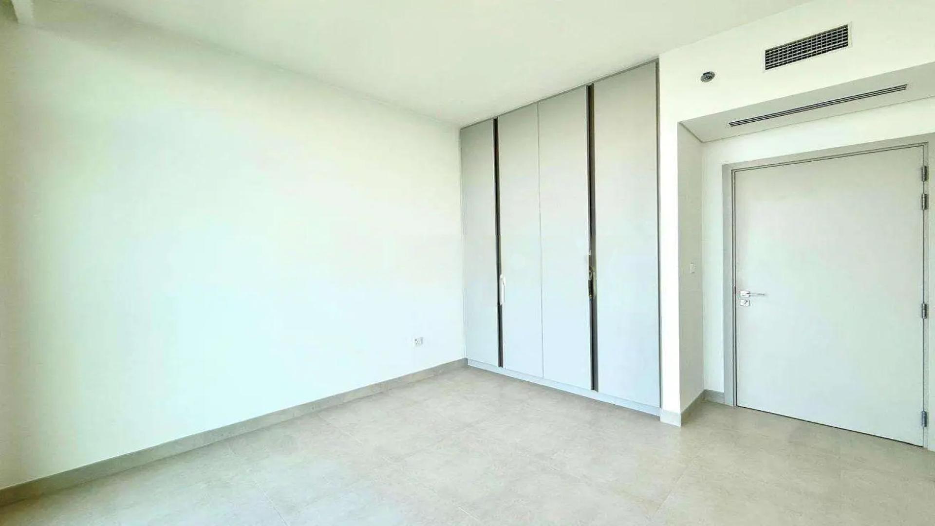 "Modern kitchen in Dubai Creek Harbour apartment, featuring sleek cabinetry and spacious countertops.",Empty bedroom with built-in wardrobe in Dubai Creek Harbour apartment for rent