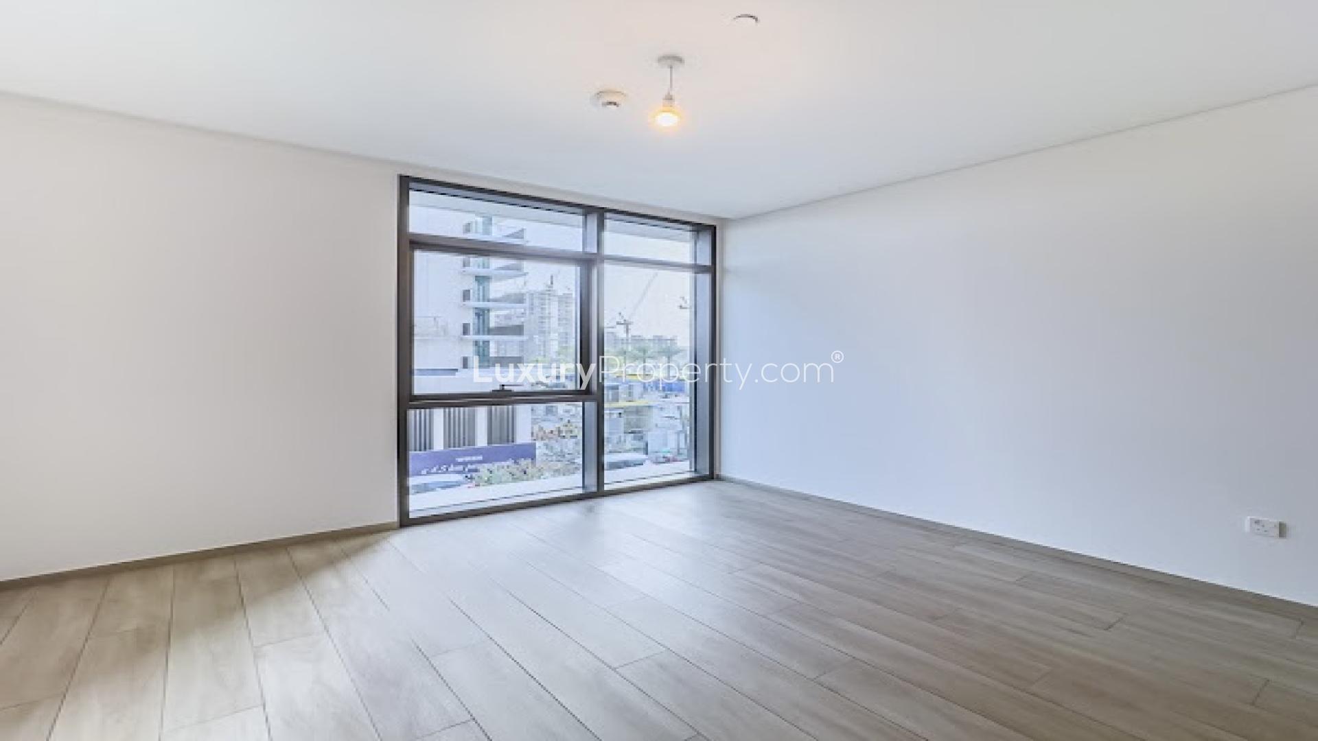 Empty room with large window in Dubai Creek Harbour apartment, Palace Residences