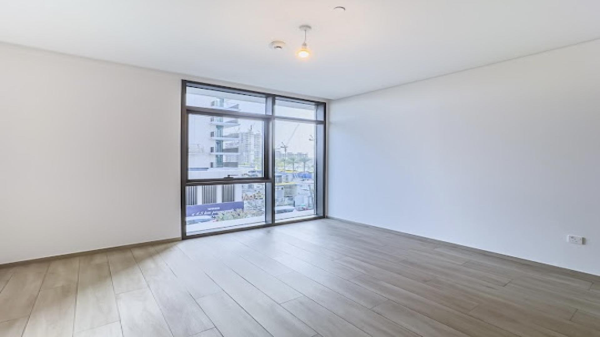 Empty room with large window in Dubai Creek Harbour apartment, Palace Residences