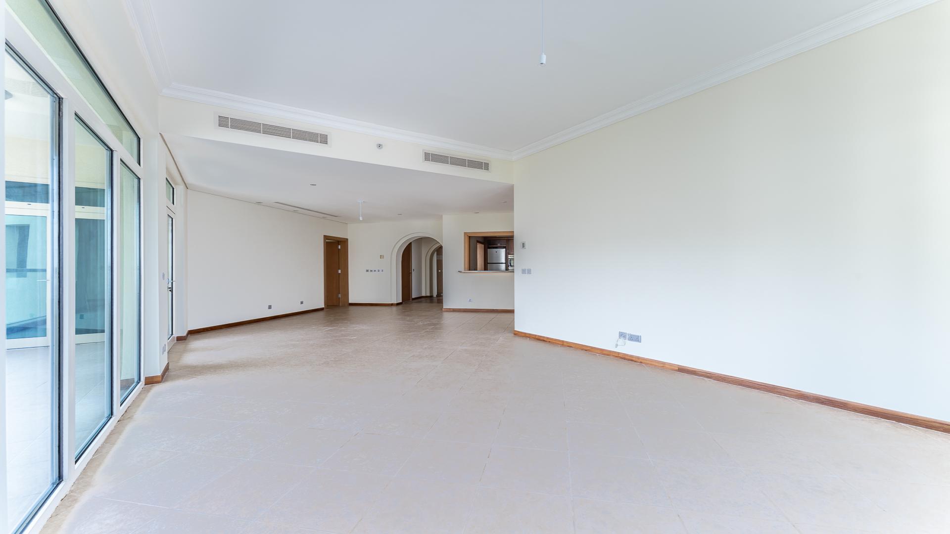 Spacious living area in Palm Jumeirah Shoreline Apartments, featuring tiled floors and kitchen view