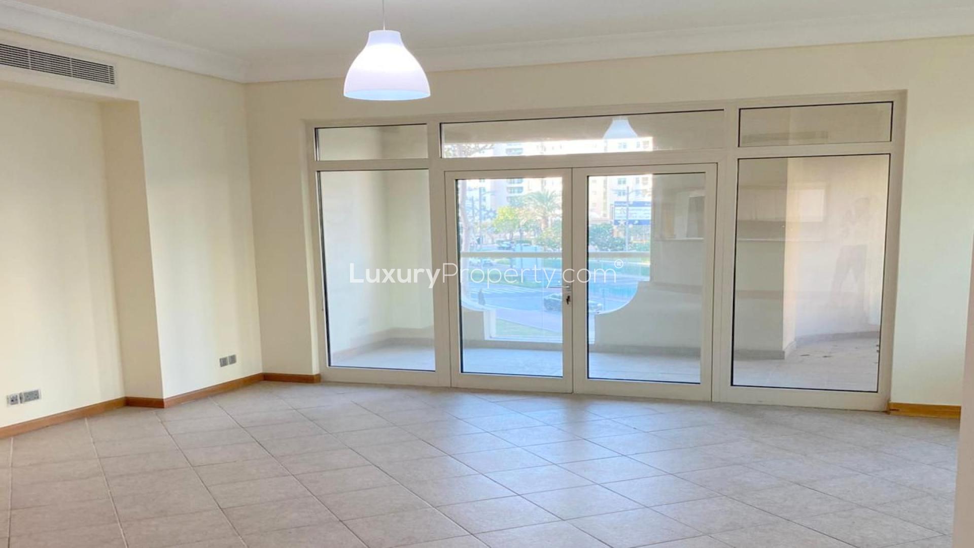 Empty room in Shoreline Apartments, Palm Jumeirah with large window and tiled floor