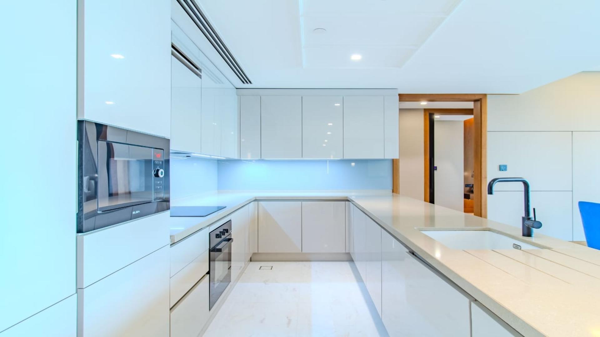 Modern living room in Bluewaters apartment, open kitchen, stylish decor, Ain Dubai view