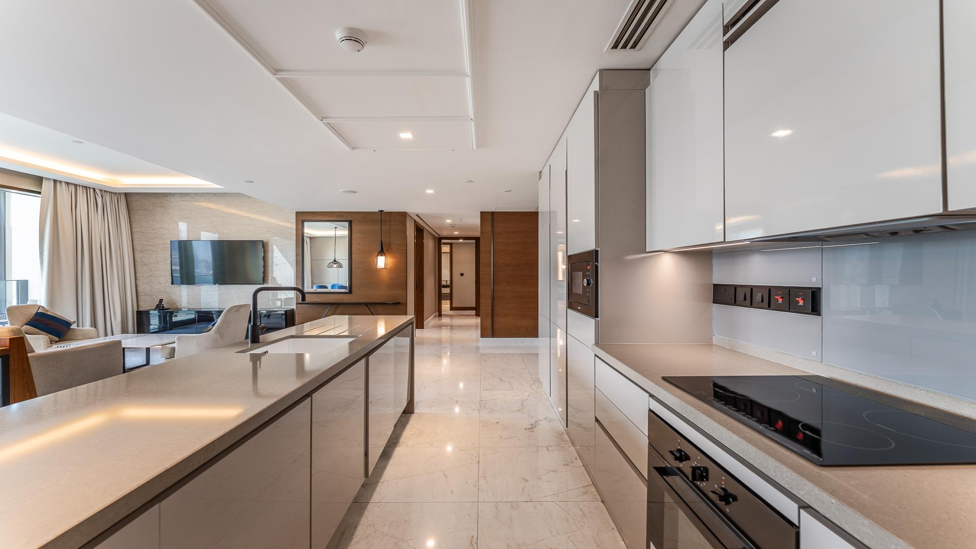 Modern open-plan kitchen and living area in Bluewaters apartment, Dubai skyline view
