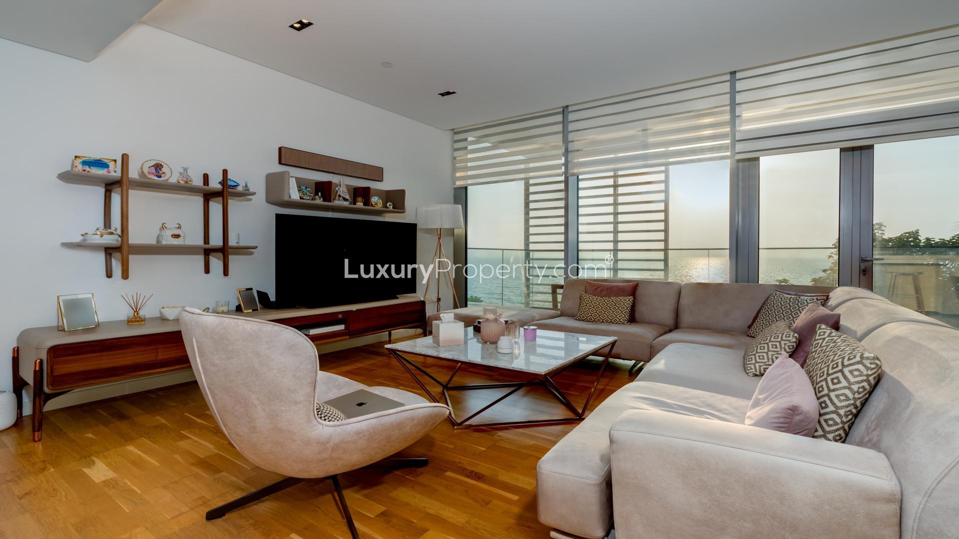 Furnished living room in Bluewaters apartment, featuring modern decor and entertainment center