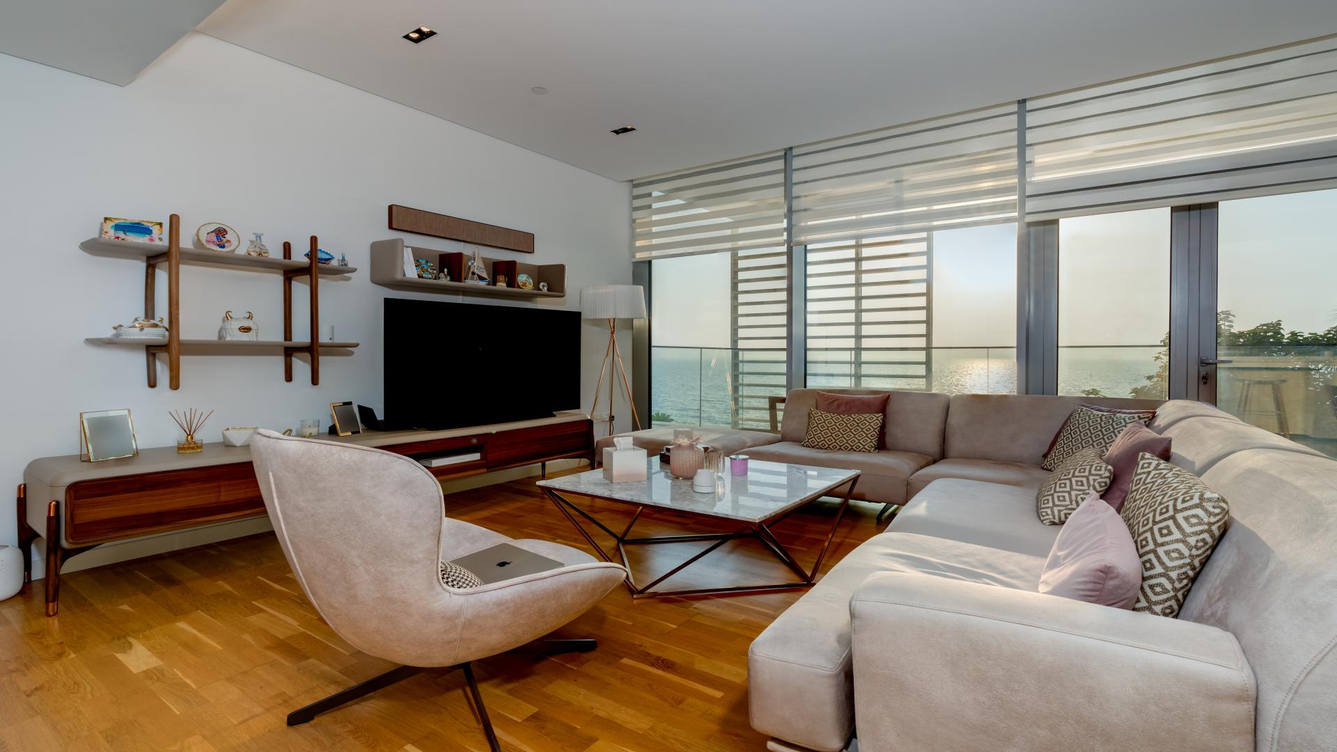 Furnished living room in Bluewaters apartment, featuring modern decor and entertainment center