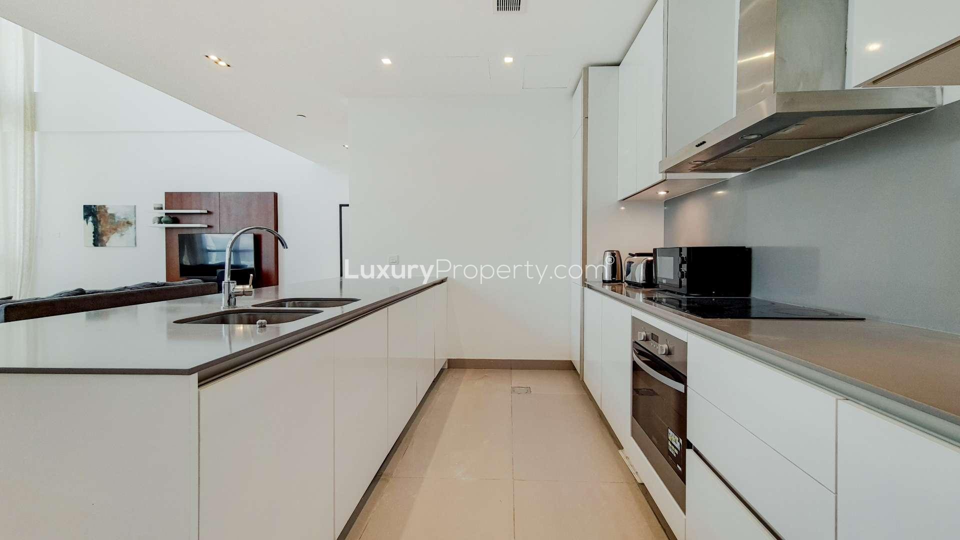 Furnished City Walk apartment living room with large windows and modern staircase