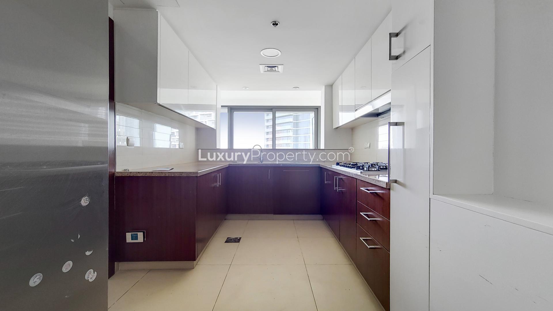 Modern kitchen in Burj Vista apartment, Downtown Dubai, featuring sleek cabinetry and large window