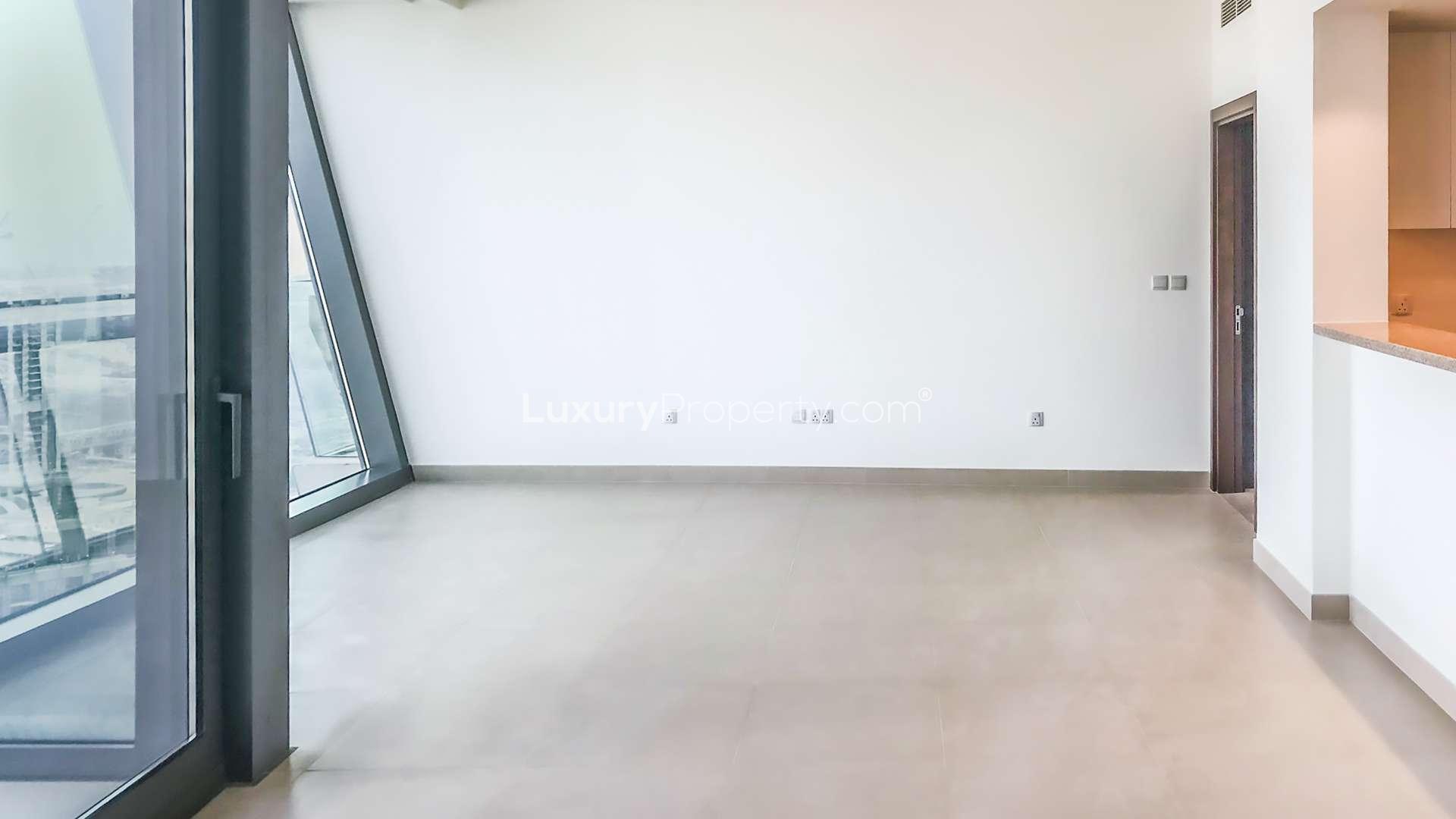 Empty apartment room with large window offering stunning Downtown Dubai skyline view, Burj Vista