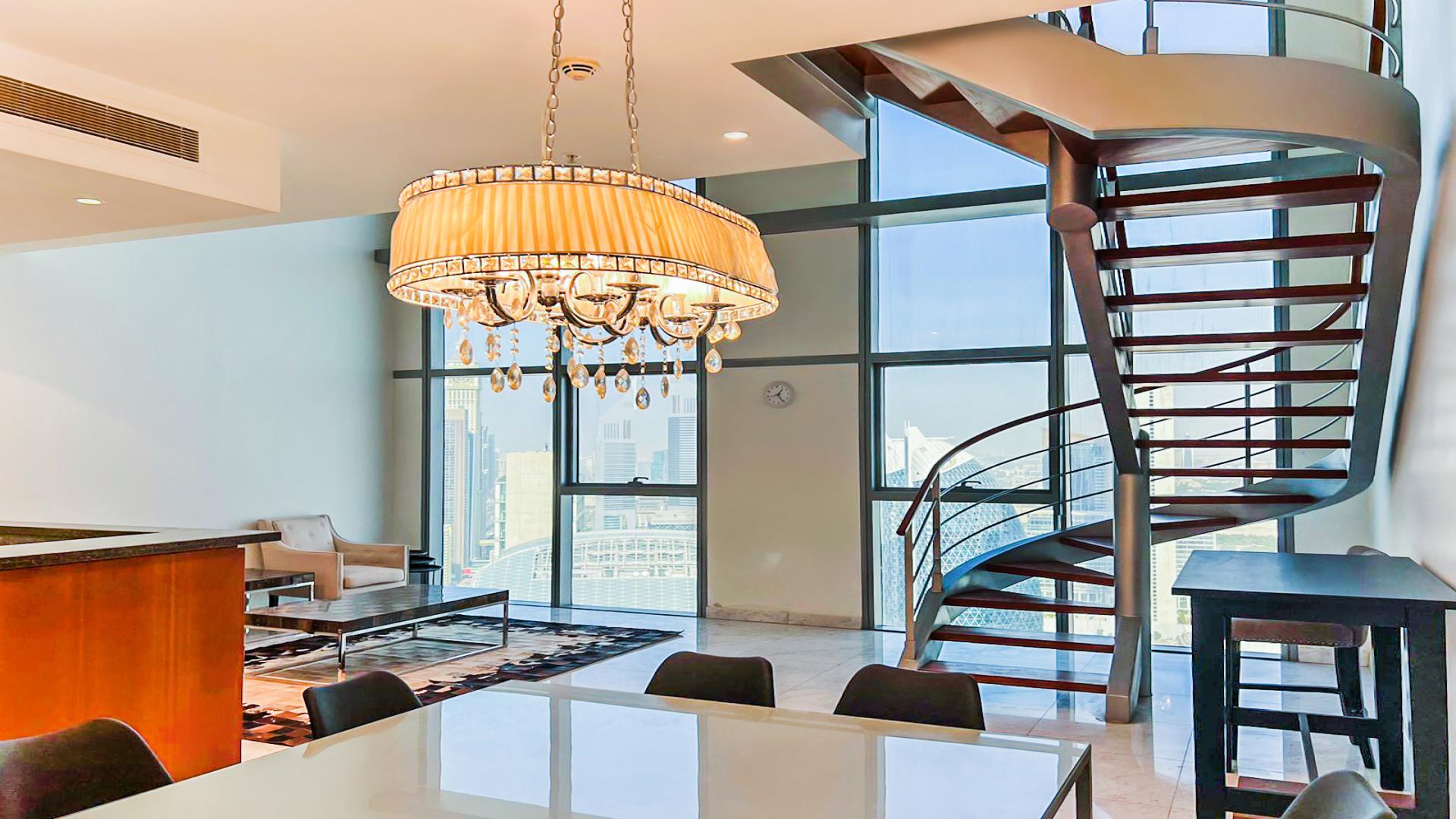 Luxury duplex interior with modern staircase and chandelier in DIFC Central Park Tower