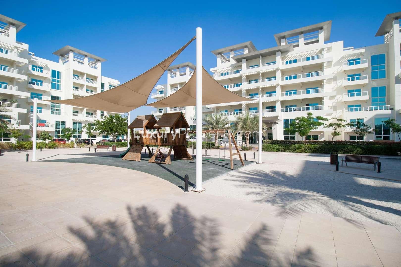 Empty living room in Jumeirah Heights duplex apartment with balcony and city view