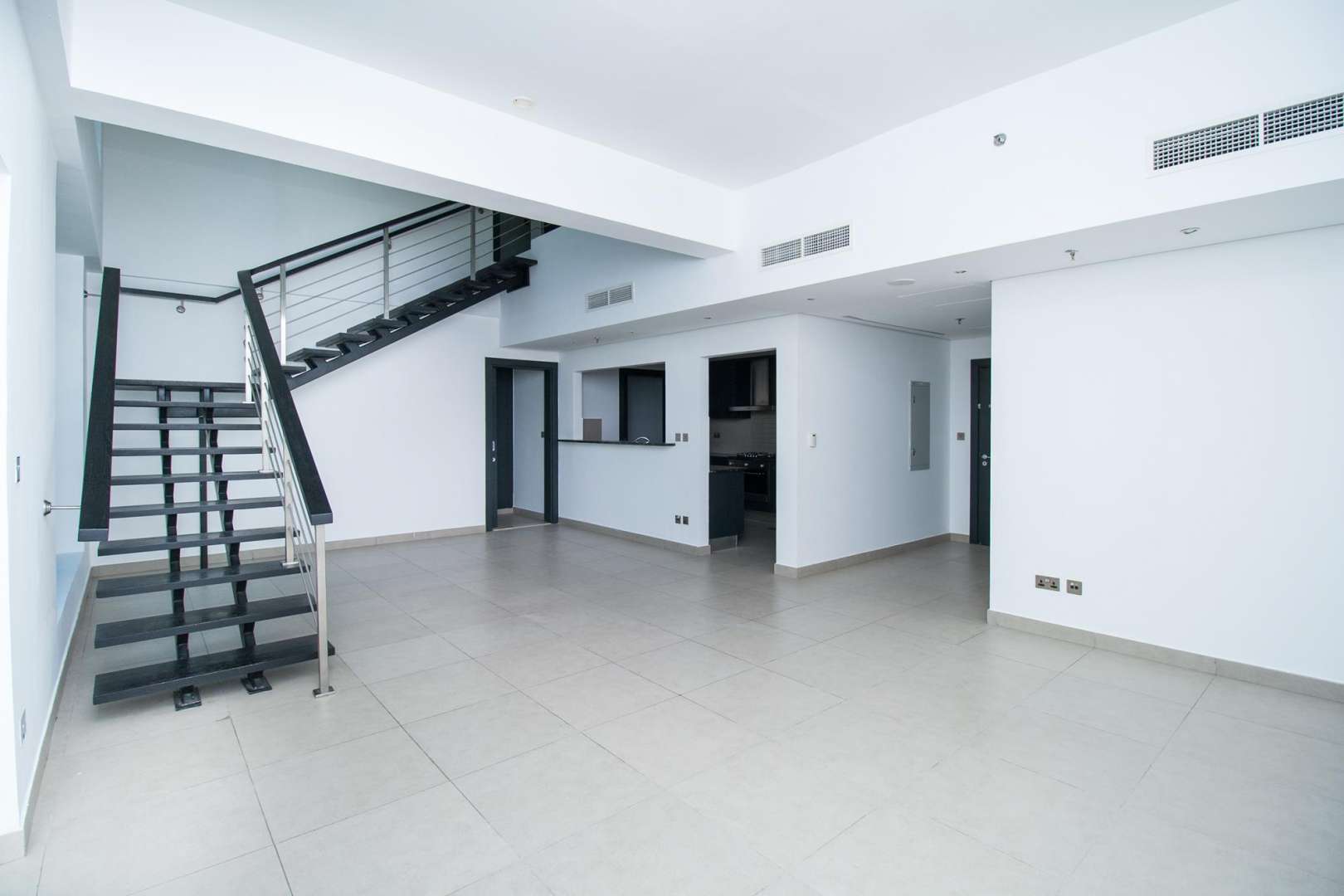 Spacious living area with staircase in Jumeirah Heights 3-bedroom duplex apartment for rent