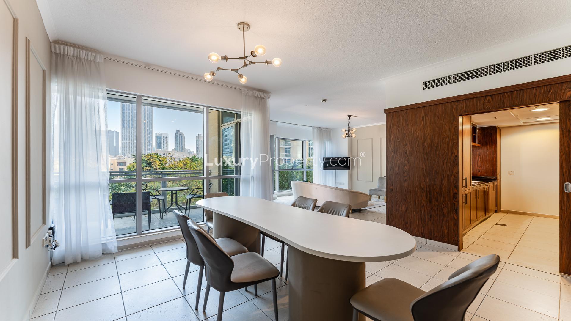 "Balcony view from 3-bedroom apartment in The Residences, Downtown Dubai, showcasing city skyline.",Modern dining area with balcony view in Downtown Dubai apartment, The Residences 2