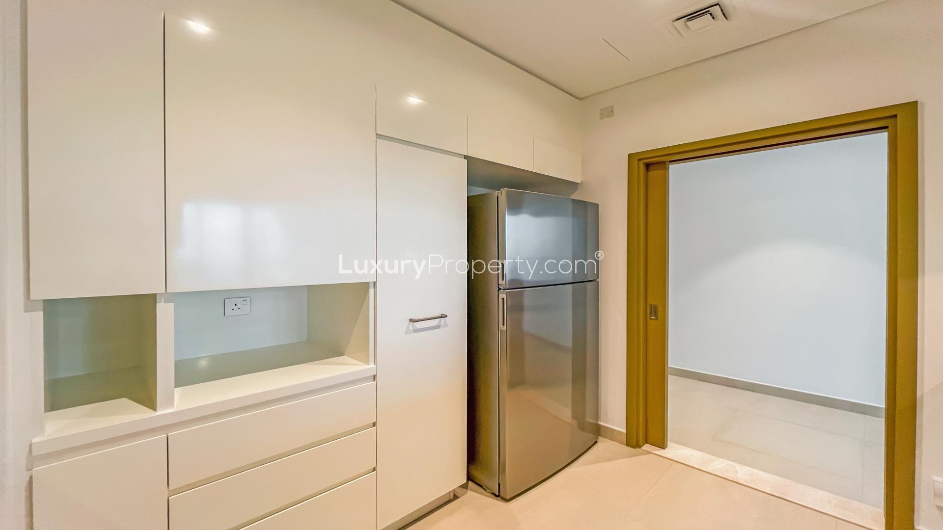 Modern kitchen in three-bedroom Downtown Dubai apartment for rent, featuring sleek cabinetry and appliances