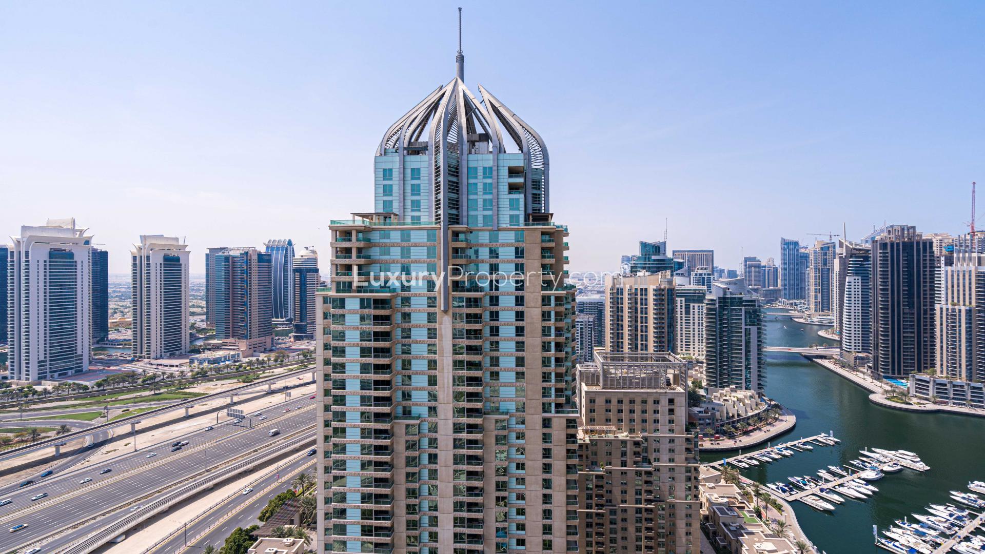 Spacious living room in Dubai Marina apartment with large windows and tile flooring