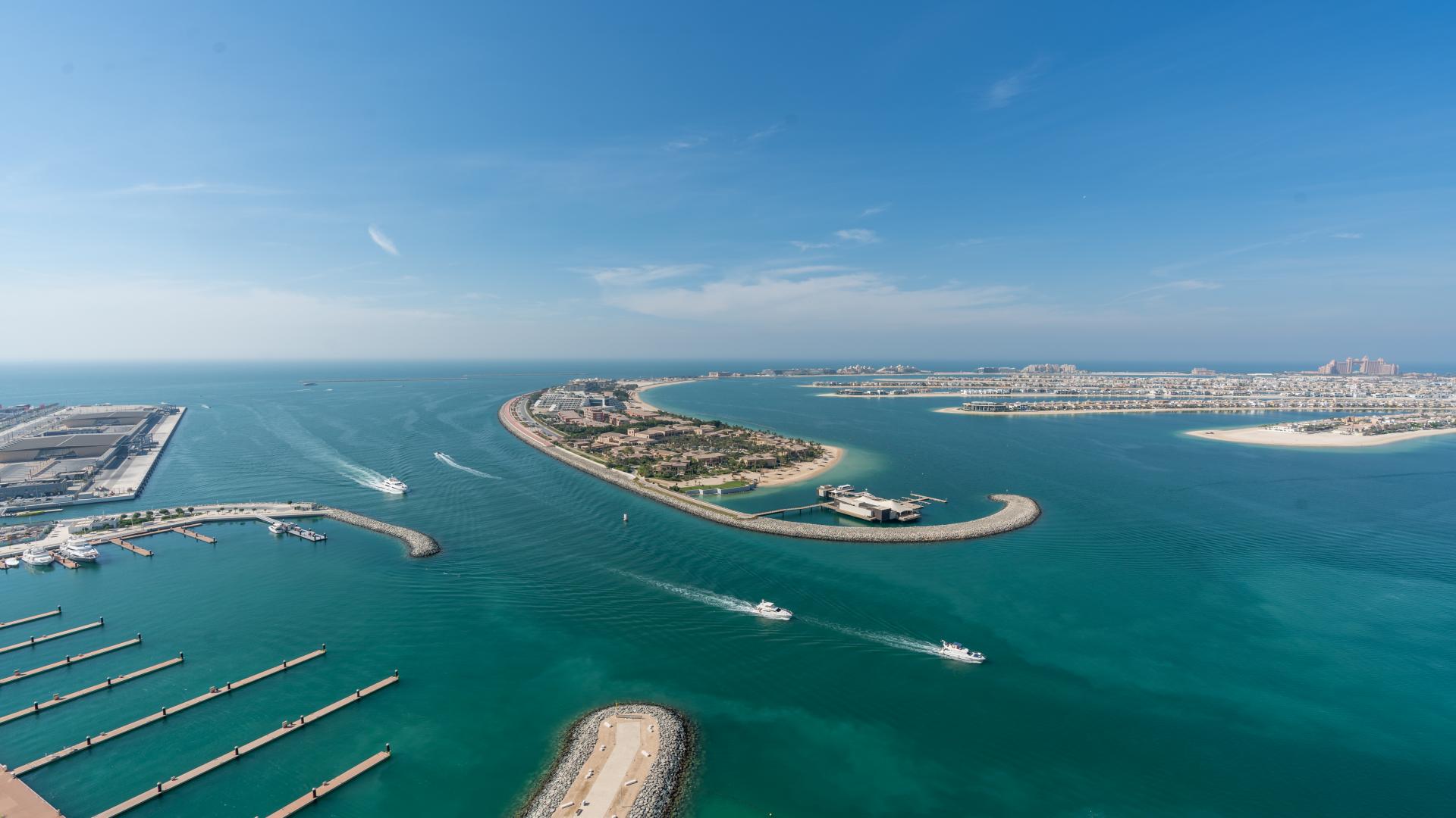 "Stunning ocean view from Beach Vista apartment balcony in Emaar Beachfront, Dubai Harbour.",Aerial view of Emaar Beachfront marina and coastline in Dubai Harbour, clear blue skies