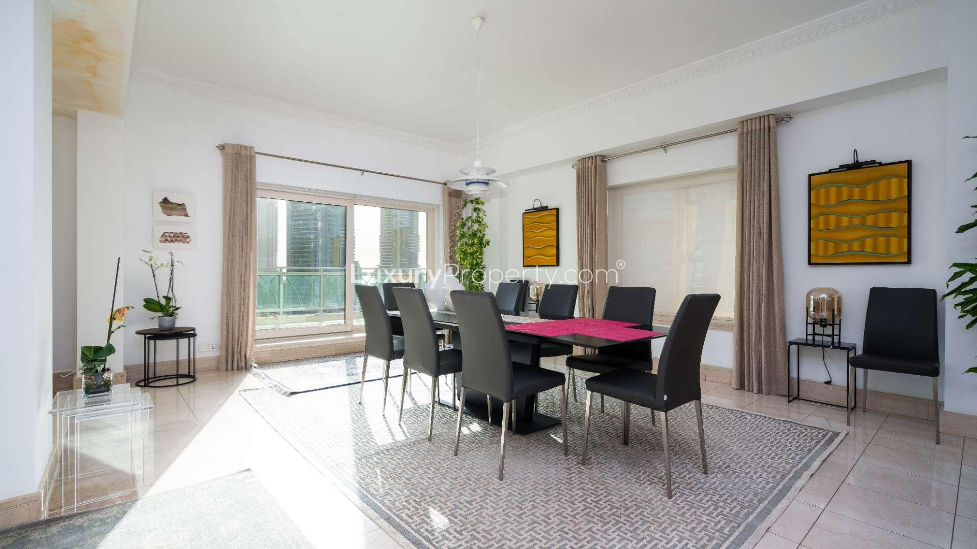 "Spacious balcony view of Dubai Marina skyline from Emaar Six apartment for rent.","Bright dining area in spacious Dubai Marina apartment, Emaar Six Towers, for rent.",Spacious bedroom with modern decor and exercise equipment in Emaar Six, Dubai Marina apartment