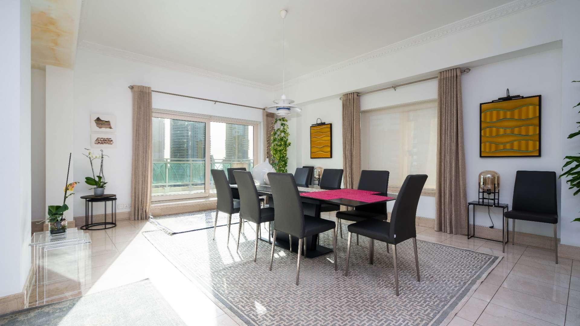 "Spacious balcony view of Dubai Marina skyline from Emaar Six apartment for rent.","Bright dining area in spacious Dubai Marina apartment, Emaar Six Towers, for rent.",Spacious bedroom with modern decor and exercise equipment in Emaar Six, Dubai Marina apartment