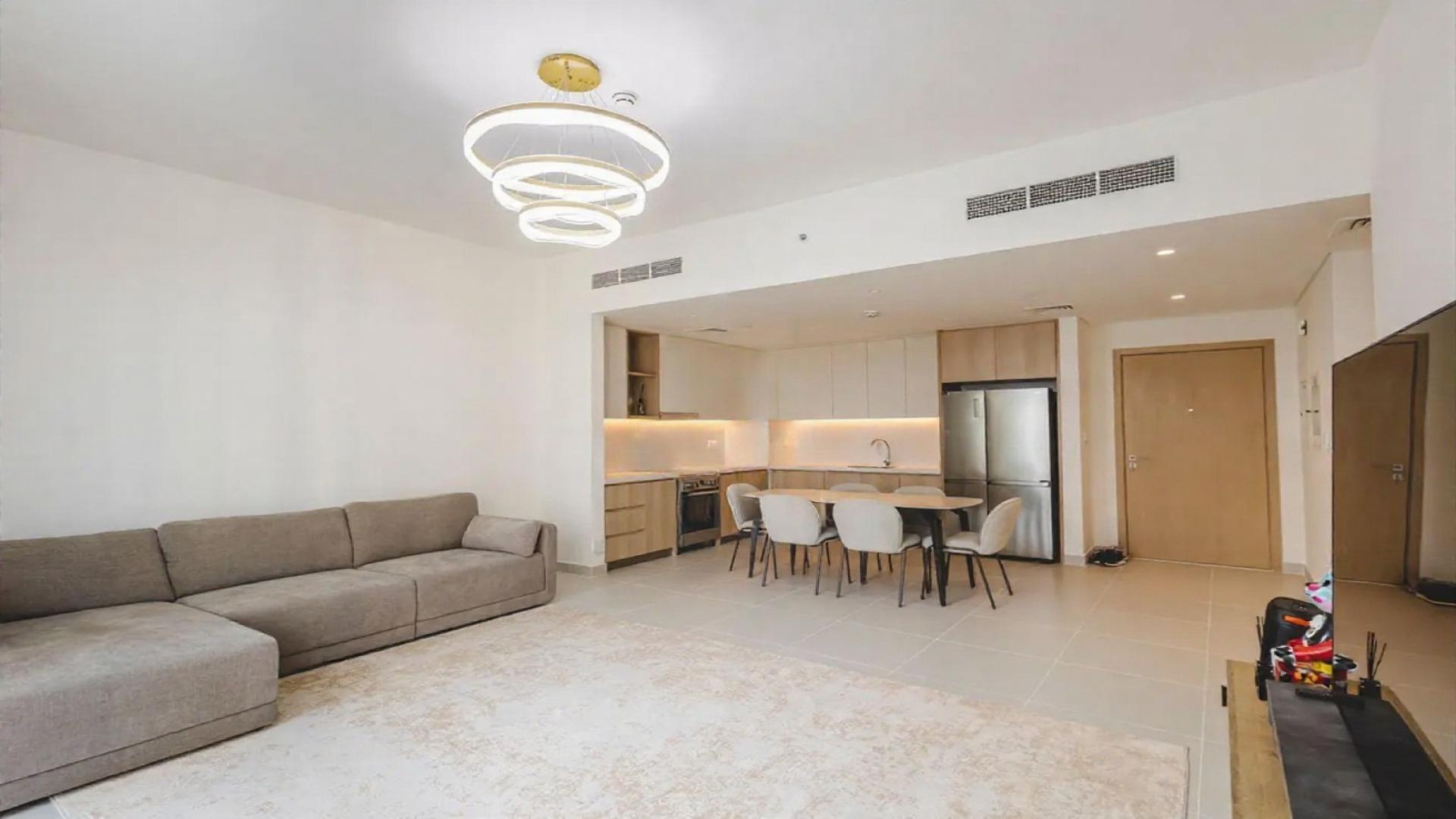 Spacious living room with large sofa and balcony view in Dubai Creek Harbour apartment