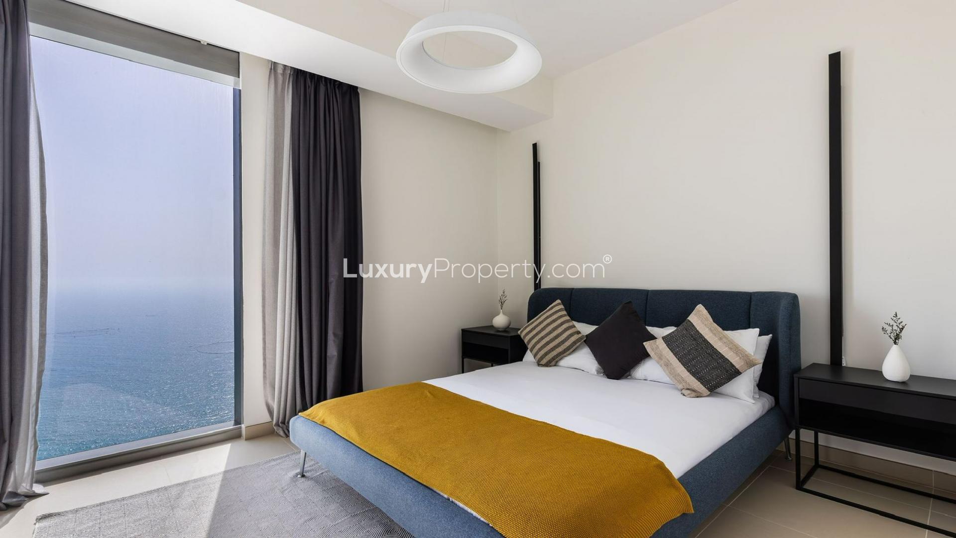 "Relaxing apartment view of Dubai Marina waterfront from cozy living room in 5242 community.",3-bedroom apartment in Dubai Marina, modern bedroom with marina view through large window