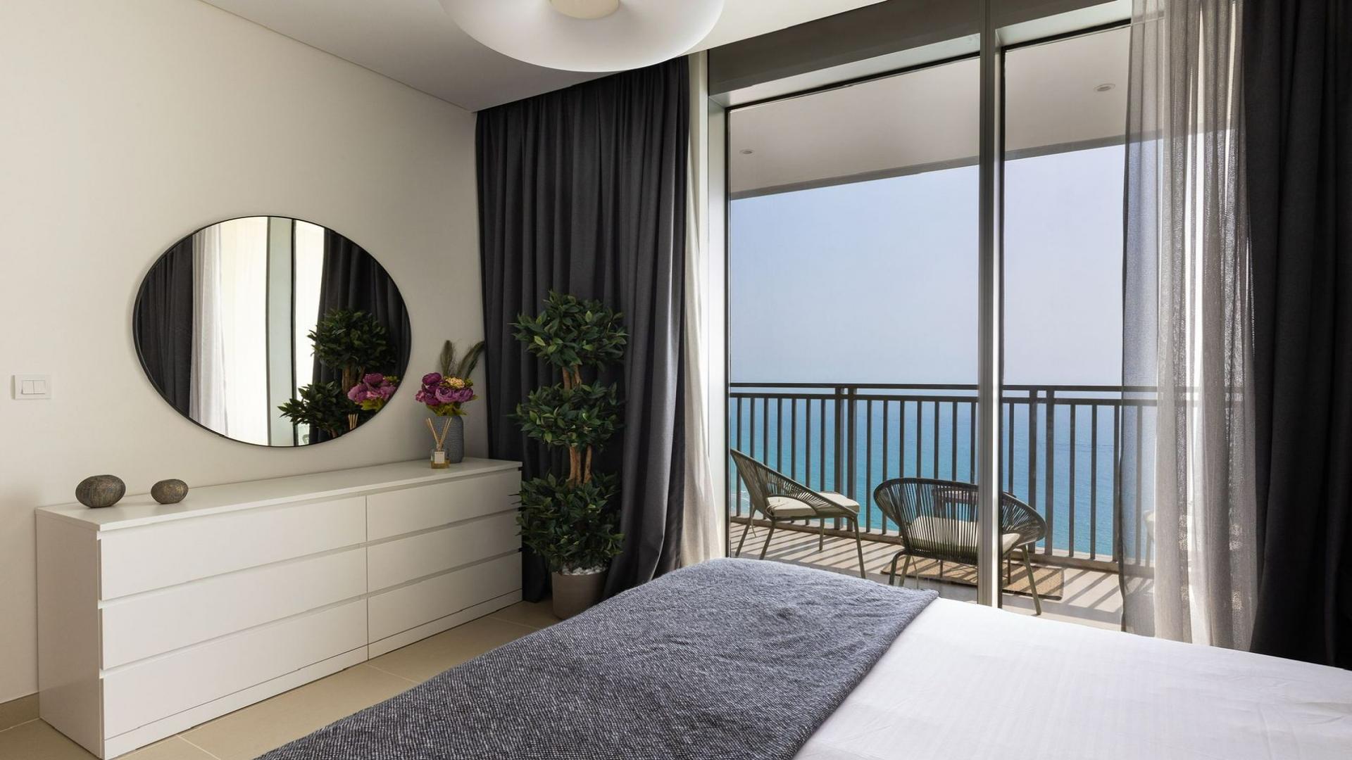 Modern bedroom in Dubai Marina apartment with balcony and stunning marina views