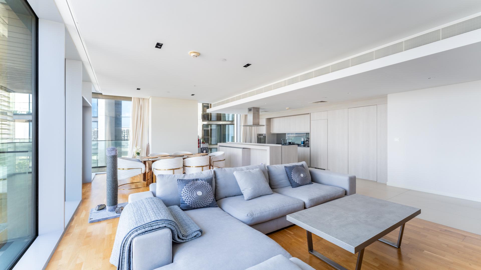 Contemporary living room in Bluewaters apartment with city views, modern furniture, and open layout