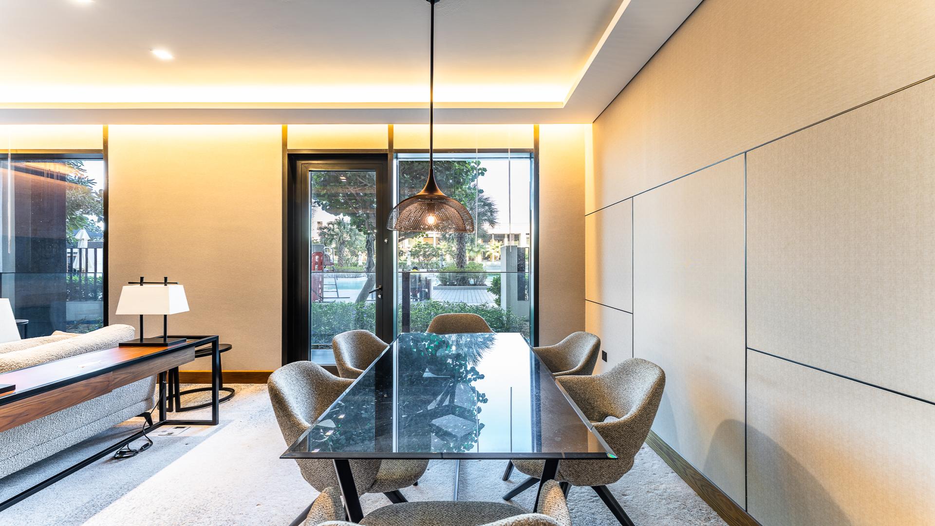 Modern furnished living room in Bluewaters Residences apartment, open layout with dining area