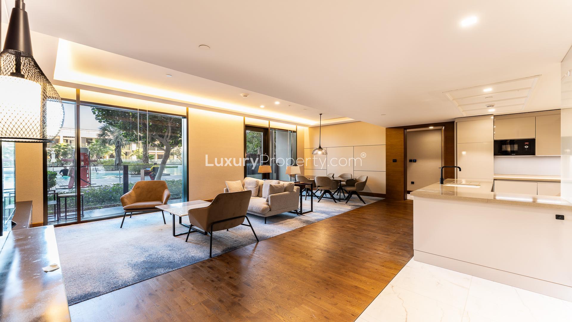 Modern furnished living area in Bluewaters Residences apartment, featuring open kitchen and pool view