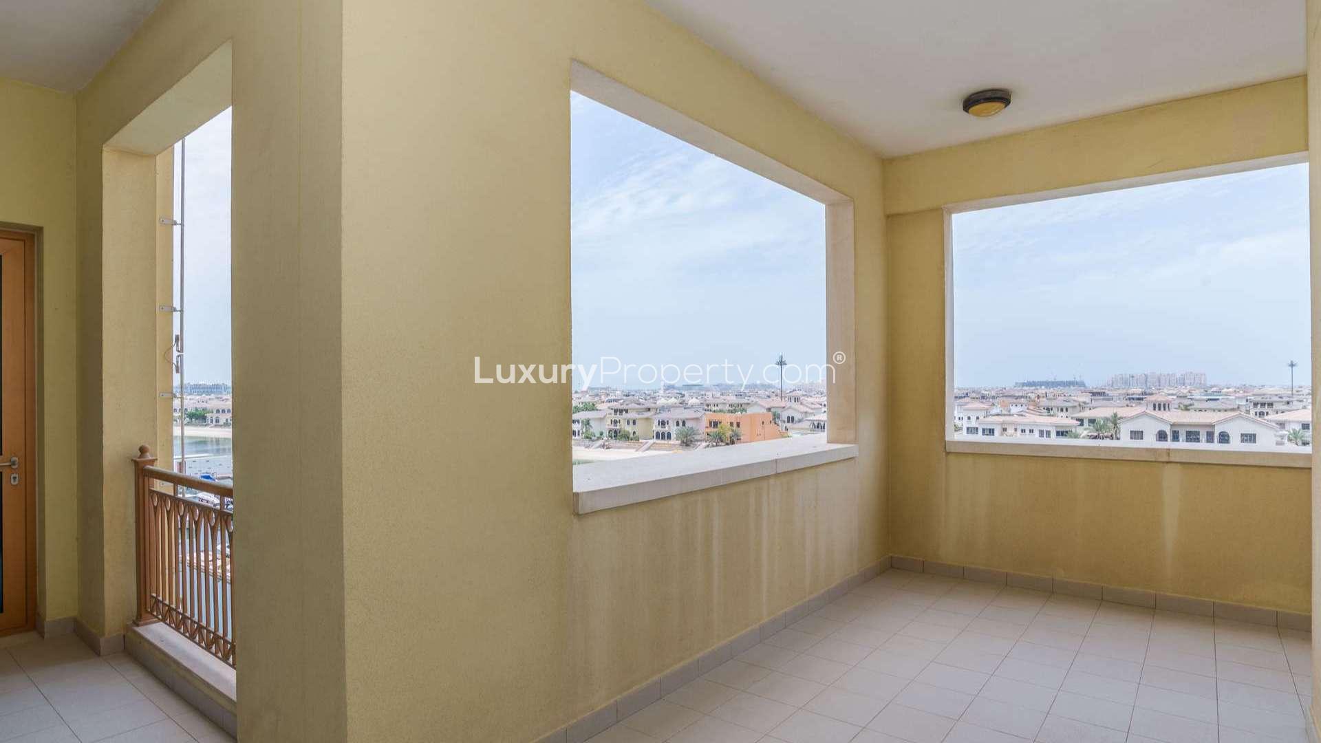 "Spacious Palm Jumeirah apartment interior with balcony offering stunning views for rent.",High-floor apartment balcony with stunning views in Marina Residences, Palm Jumeirah