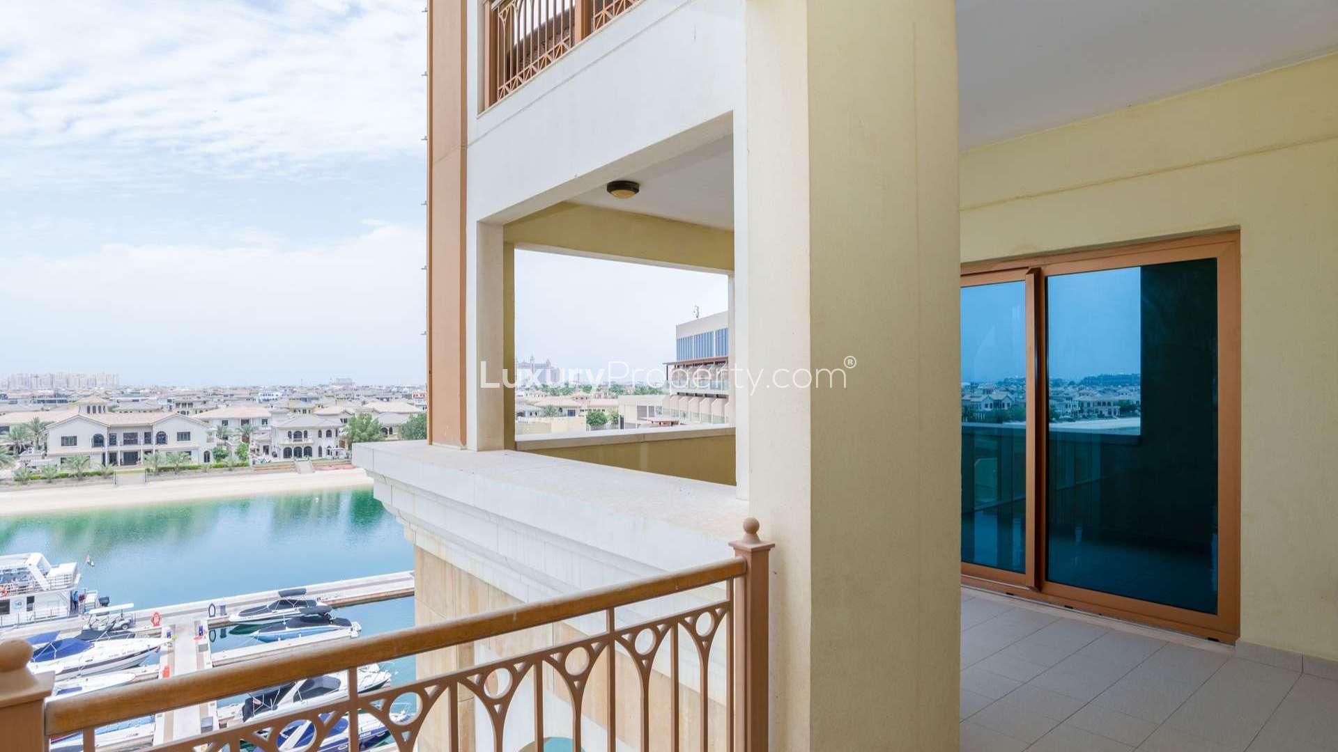 Empty apartment interior with large windows and balcony, offering stunning views in Marina Residences