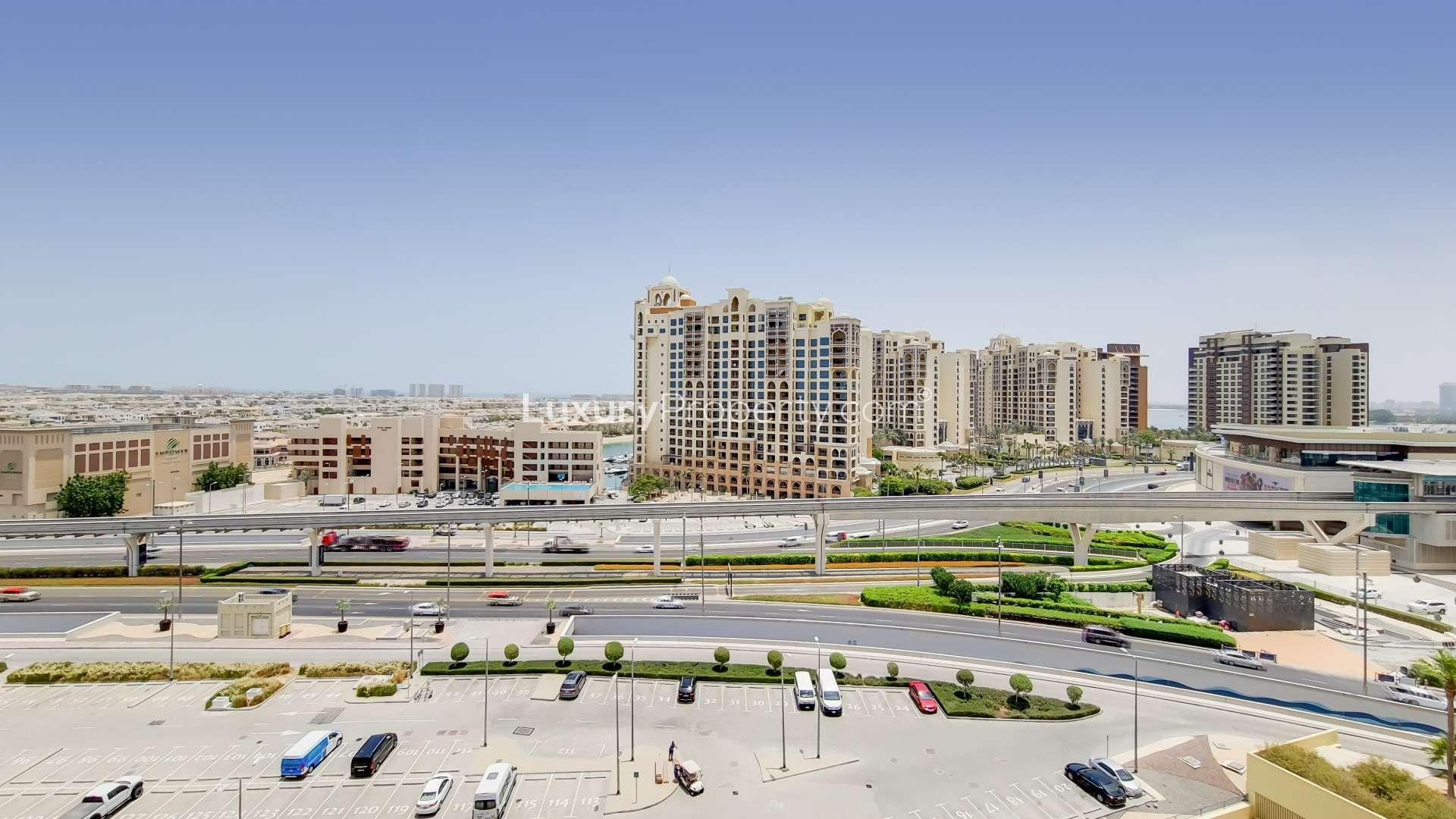 Modern kitchen in Marina Residences apartment, Palm Jumeirah, featuring wood cabinetry and stainless appliances