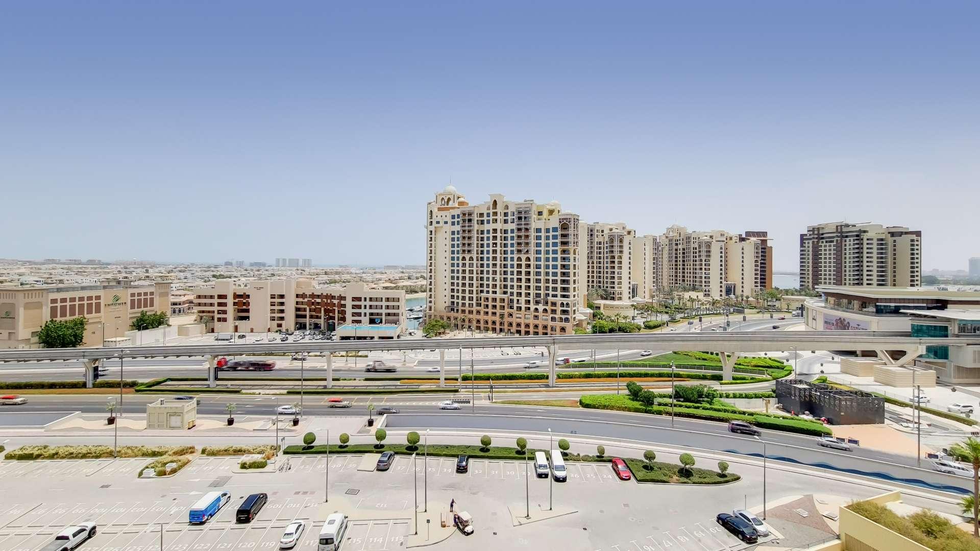Modern kitchen in Marina Residences apartment, Palm Jumeirah, featuring wood cabinetry and stainless appliances