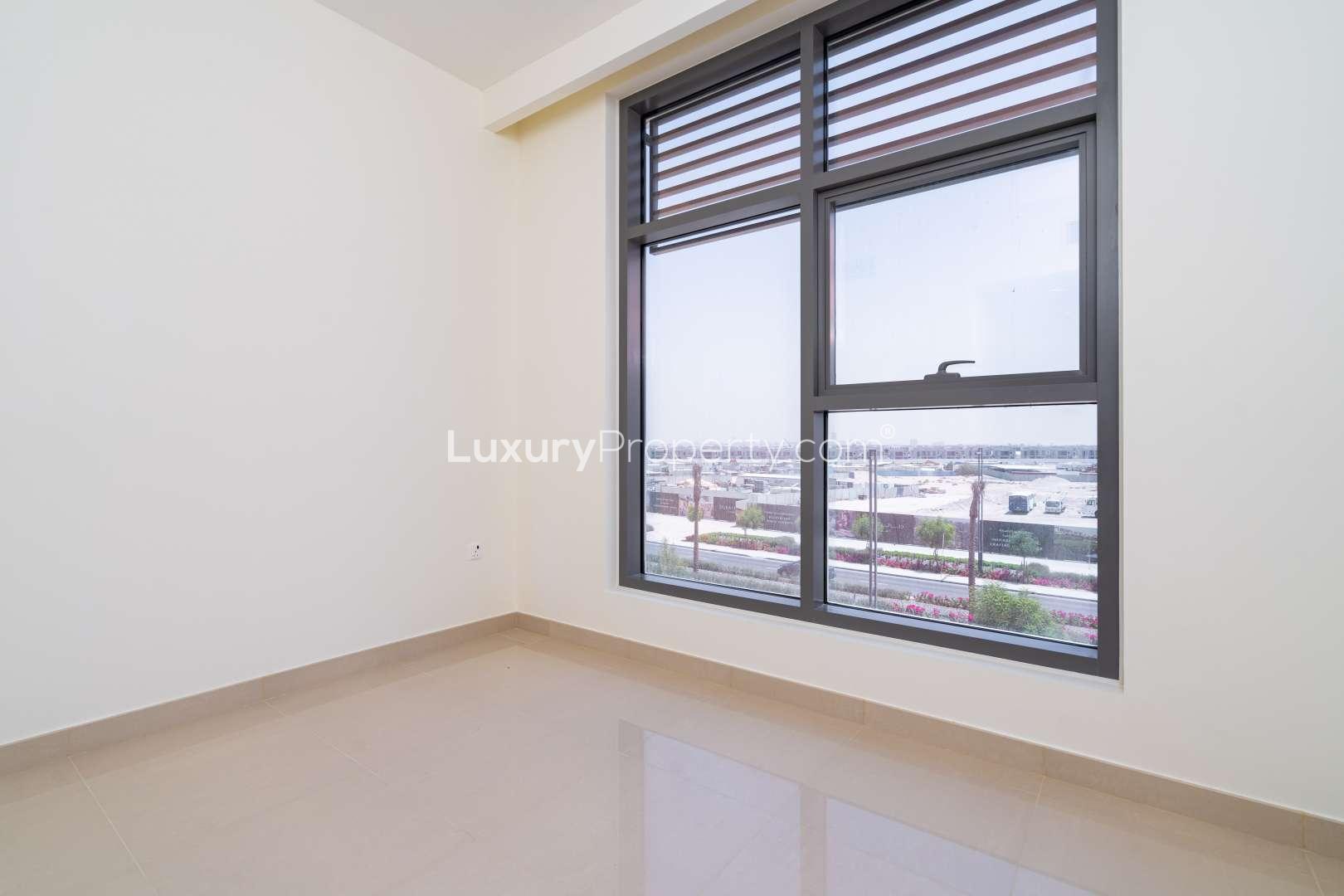 Empty room with large window view in Dubai Hills Estate apartment for rent