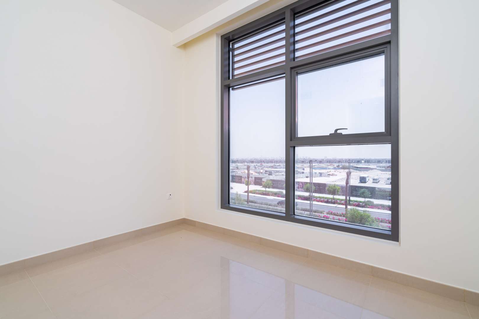 Empty room with large window view in Dubai Hills Estate apartment for rent