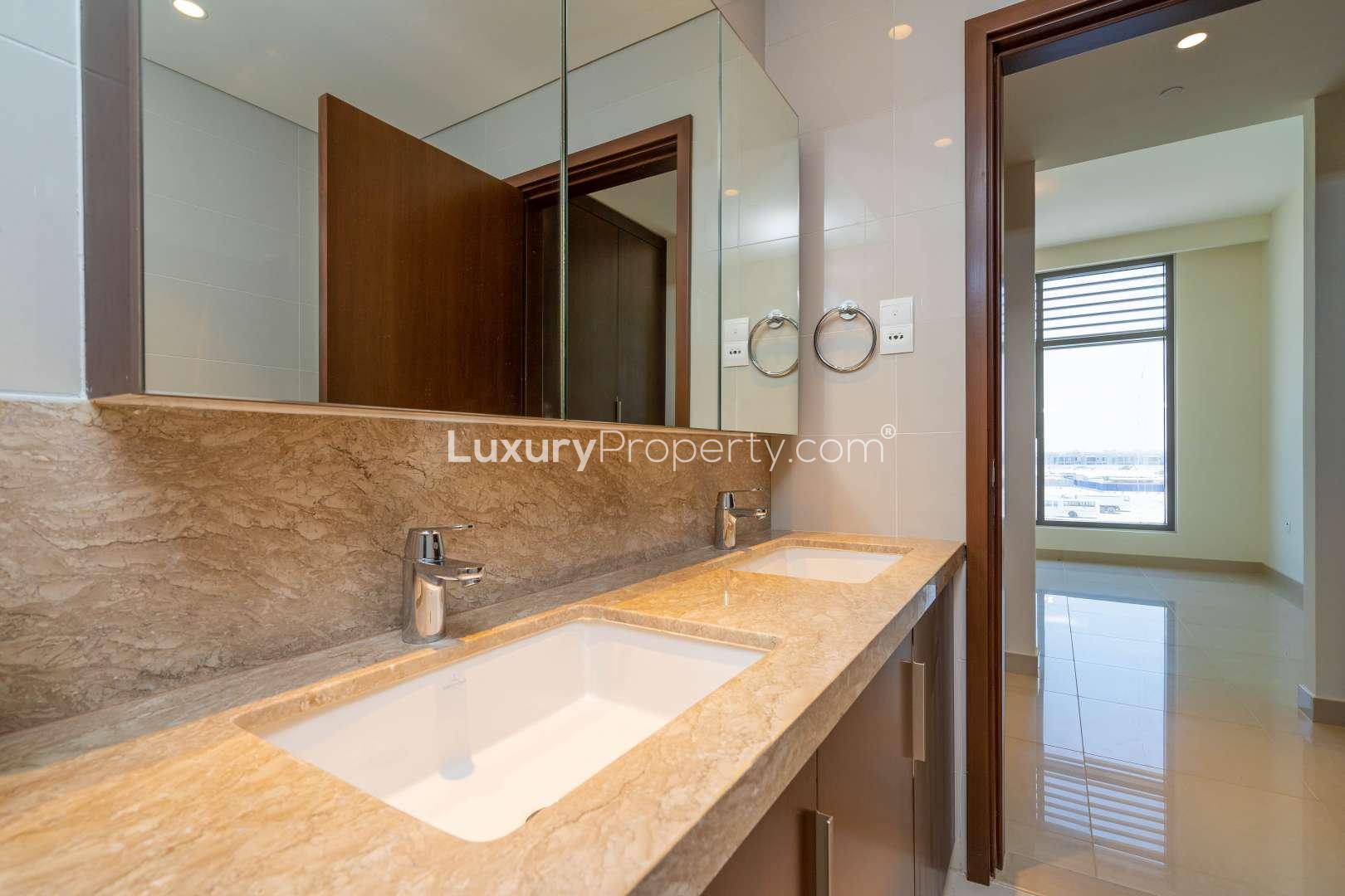 Spacious Dubai Hills Estate apartment living room with large windows and balcony view