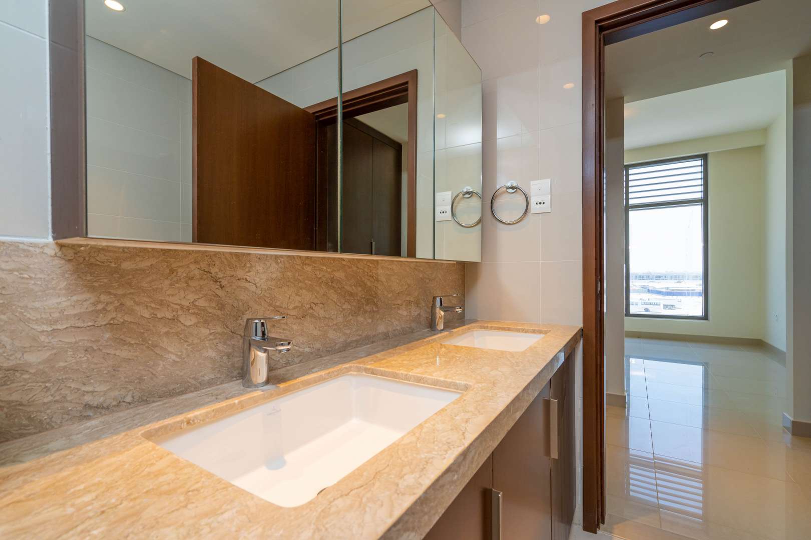 Spacious Dubai Hills Estate apartment living room with large windows and balcony view