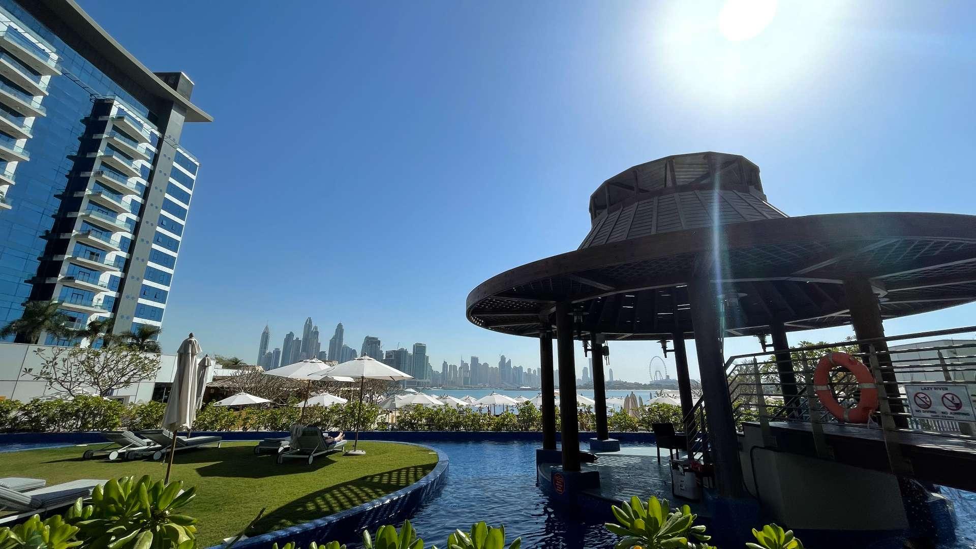 "Bright hallway and bathroom in Palm Jumeirah beachfront apartment with sea views, LP12877.",Beachfront apartment view with poolside lounge, Palm Jumeirah, Oceana community, Dubai skyline backdrop