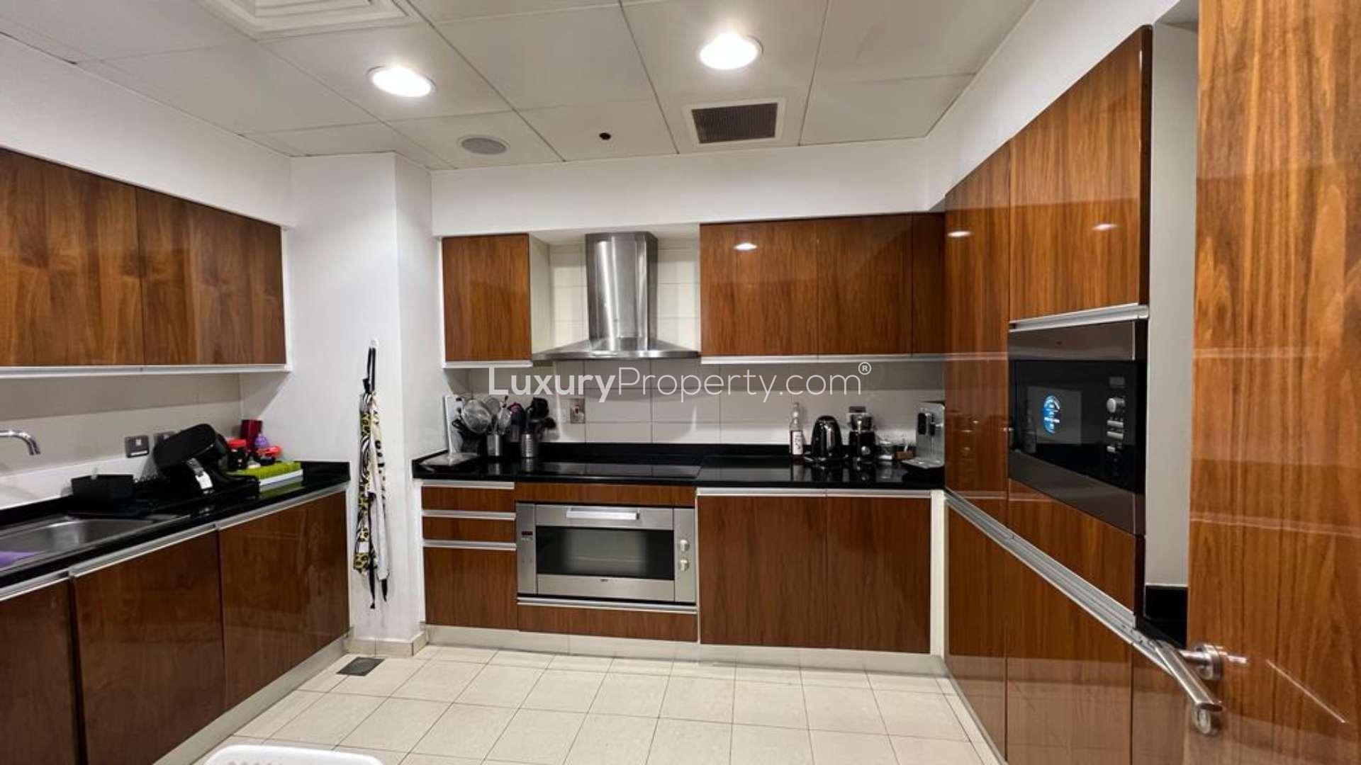 Modern kitchen in Oceana beachfront apartment, Palm Jumeirah, with sleek wooden cabinets and appliances