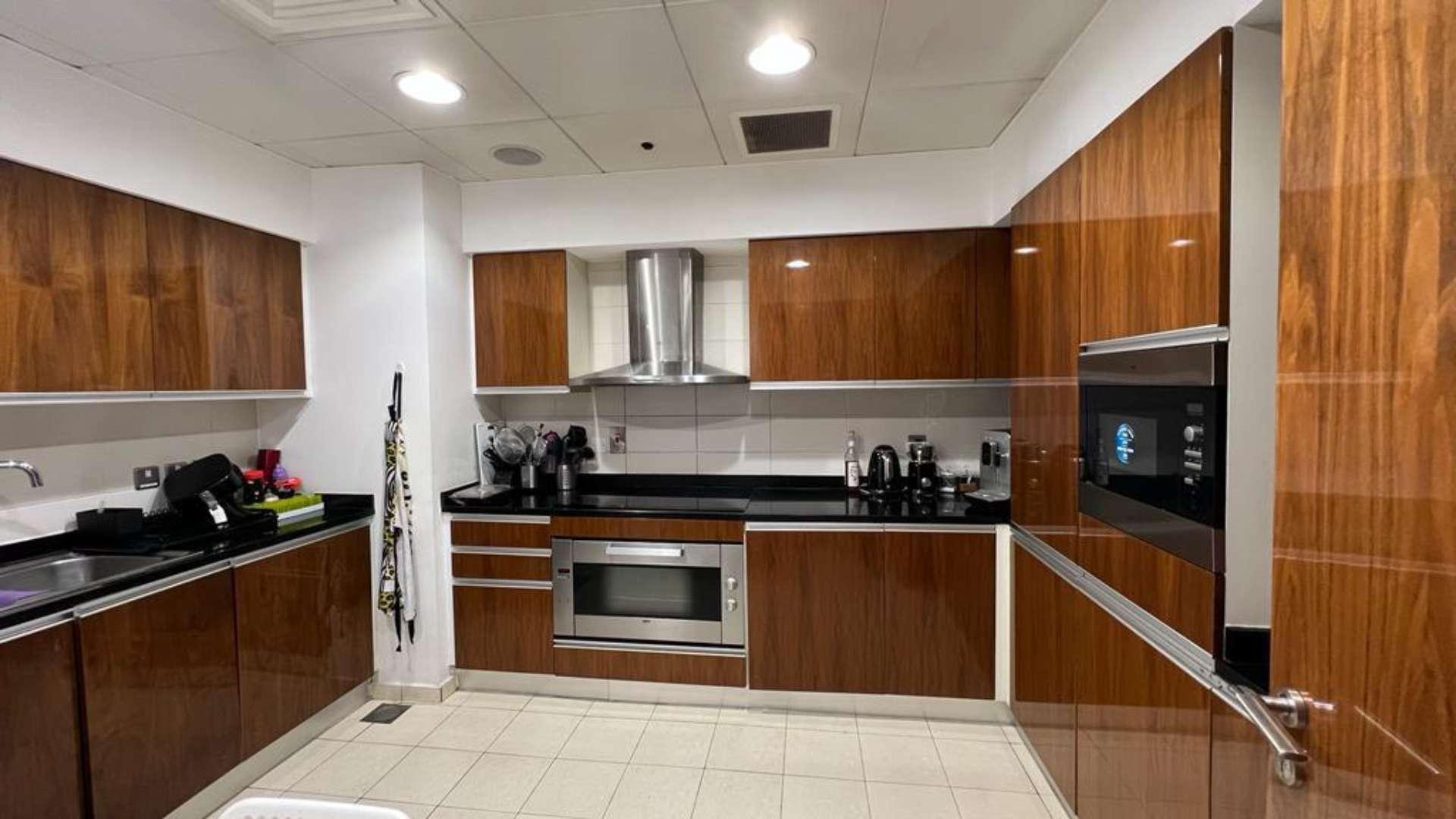 Modern kitchen in Oceana beachfront apartment, Palm Jumeirah, with sleek wooden cabinets and appliances