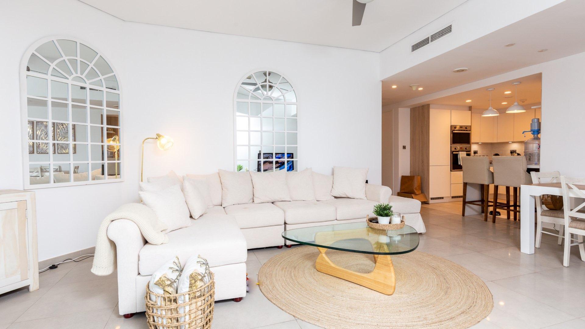 "Spacious balcony with dining area overlooking Dubai Marina in waterfront apartment, Marina Tower.",Fully furnished living room in Dubai Marina apartment, featuring modern decor and open kitchen