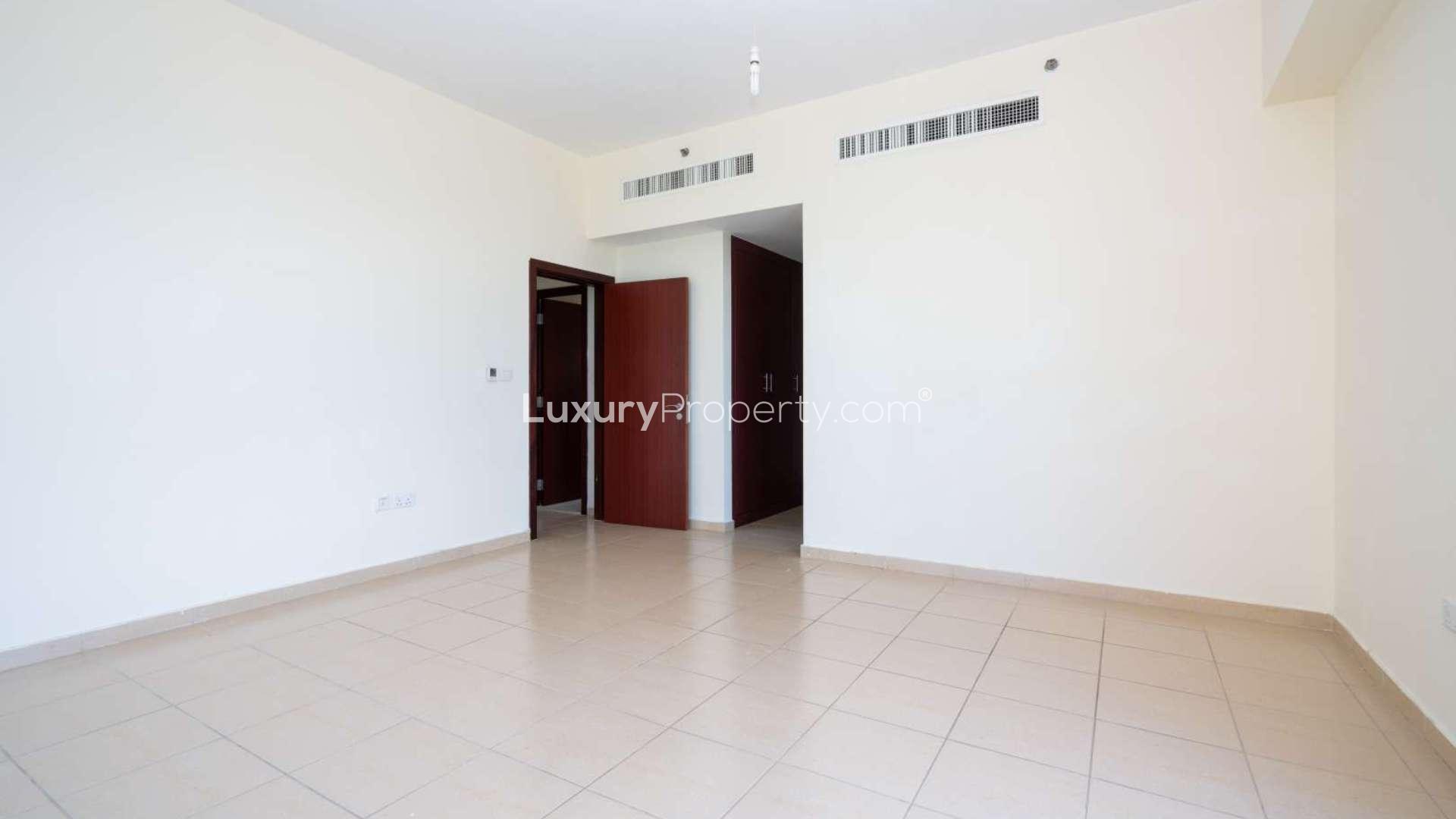 Empty bedroom in Rimal apartment, Jumeirah Beach Residence with built-in wardrobe and tiled floor