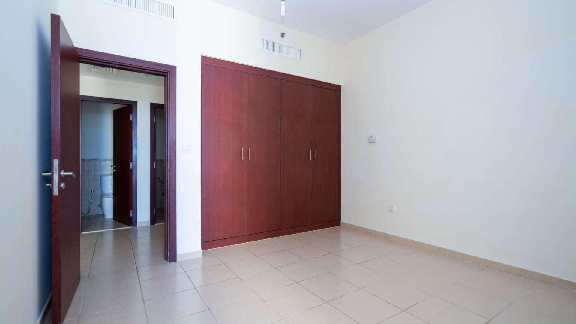 Empty room in Rimal apartment, Jumeirah Beach Residence, with tiled floors and natural light