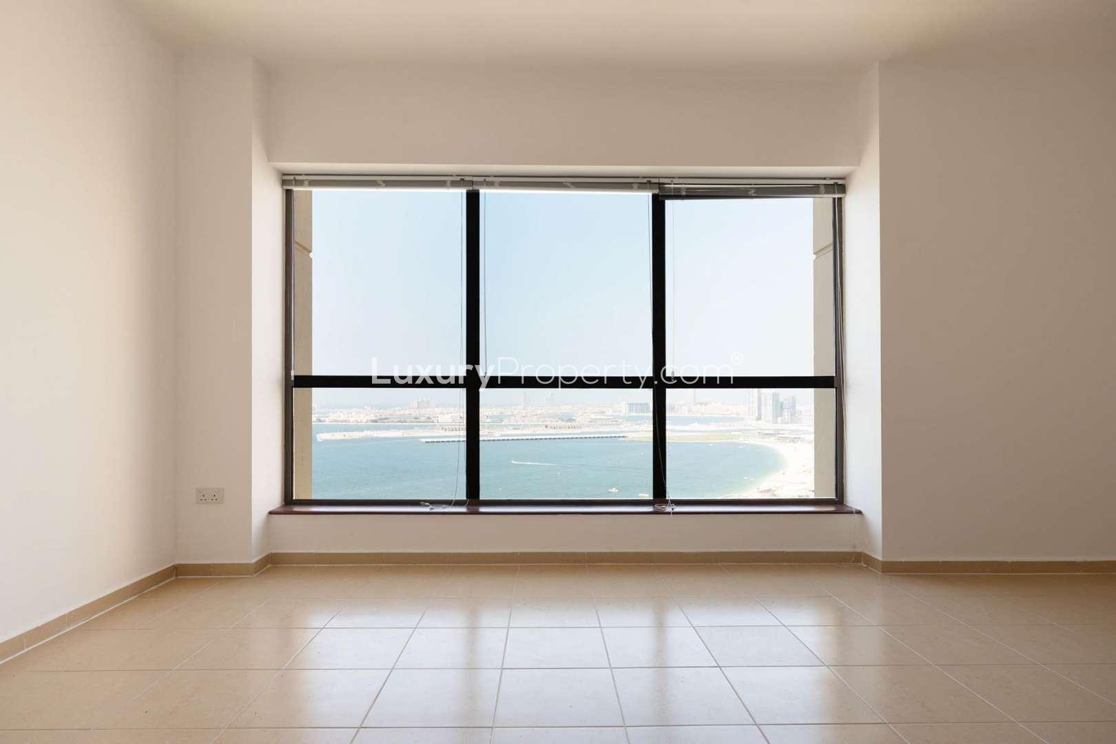 Spacious living room in 3-bedroom apartment, JBR Rimal, Dubai, with large windows and balcony access