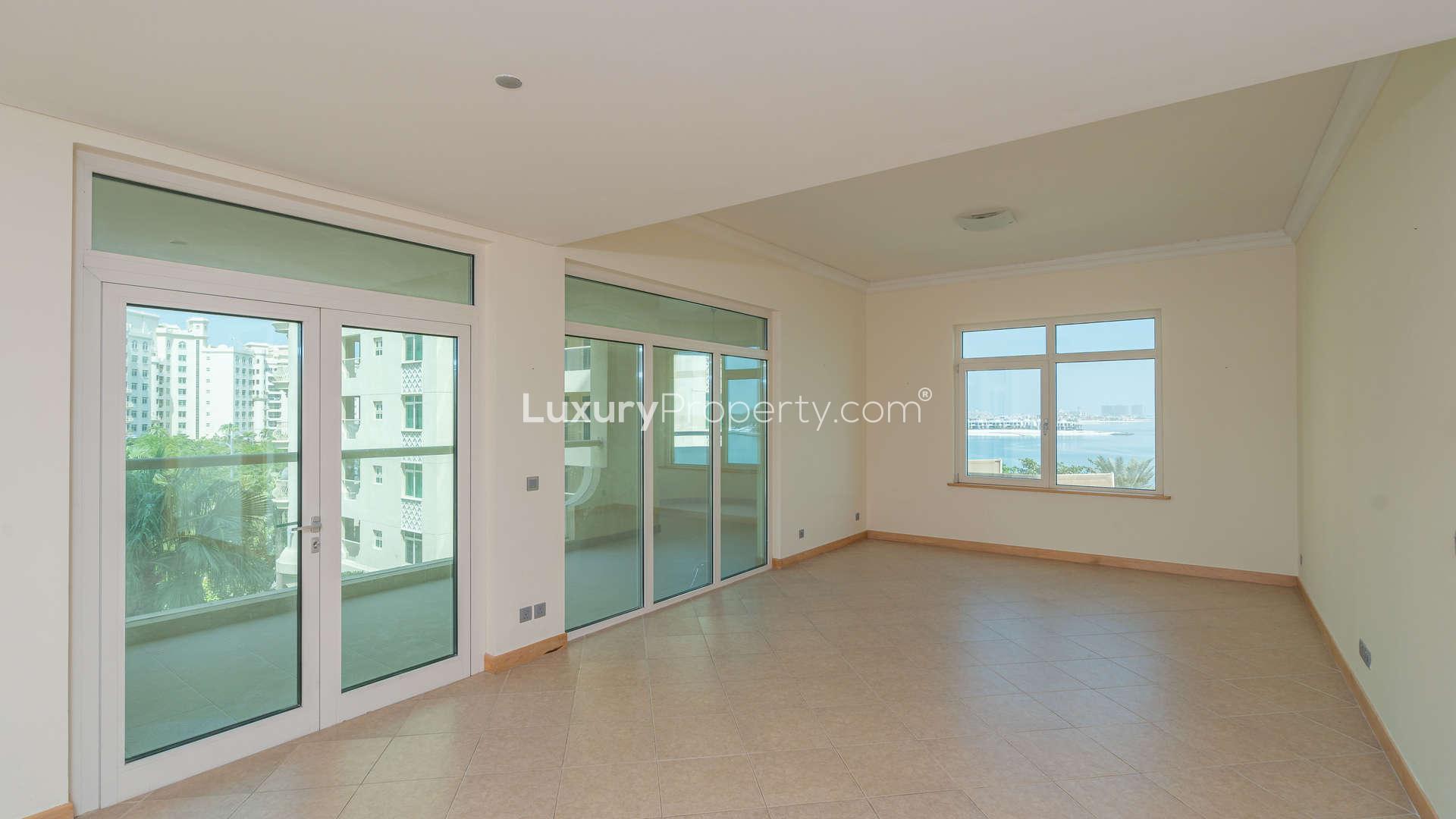 Empty bedroom with wooden doors and built-in wardrobe in Al Basri Shoreline Apartment