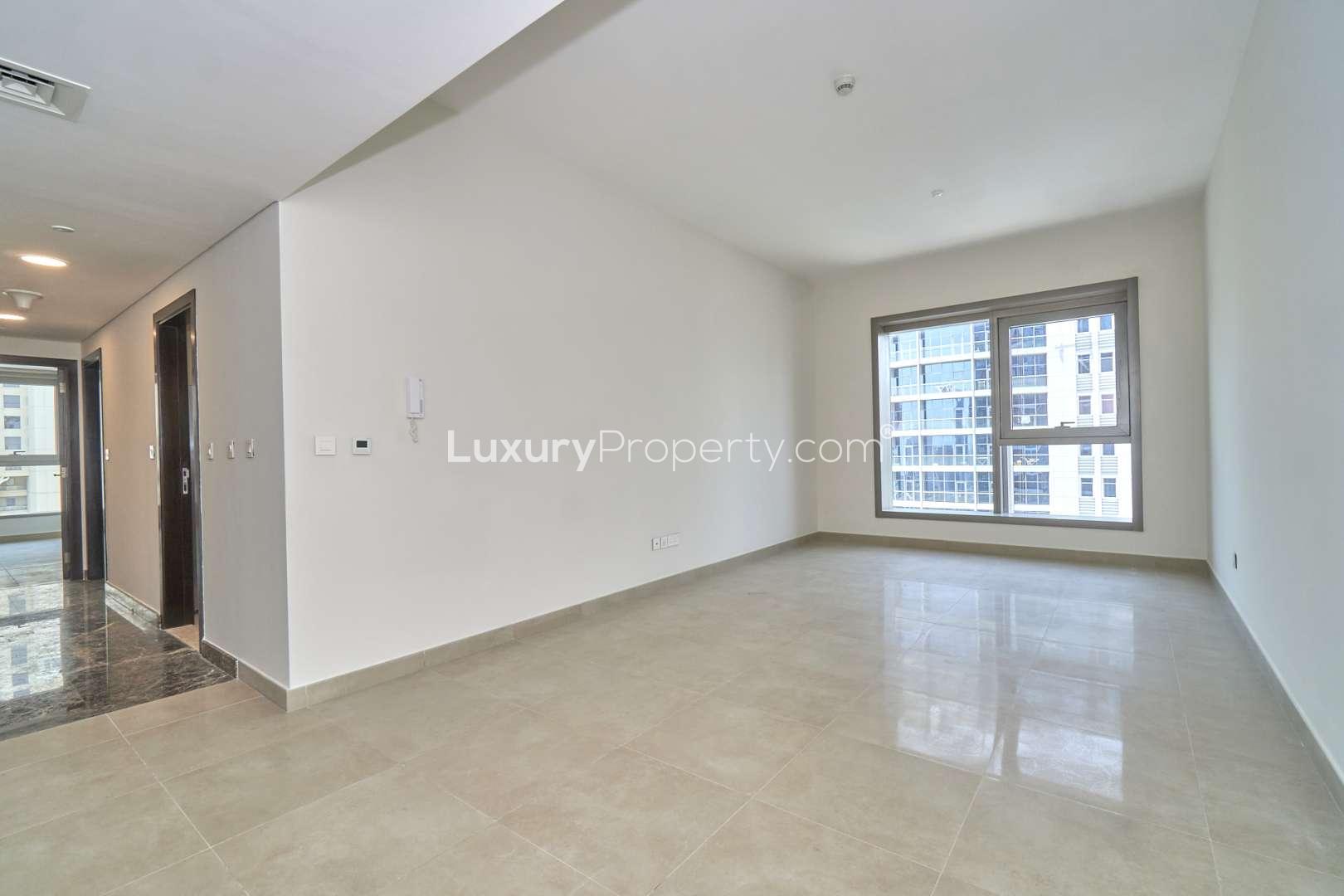 Empty living room in 3-bedroom Dubai Marina apartment, large window, tiled floor