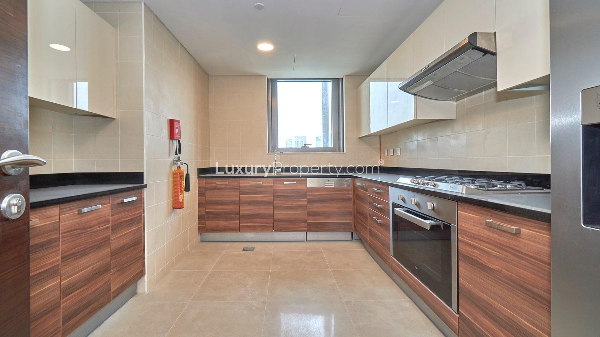 "Dubai Marina apartment balcony with stunning views of waterfront and skyline, Sparkle Towers.",Modern kitchen in Dubai Marina apartment, featuring sleek cabinetry and stainless steel appliances