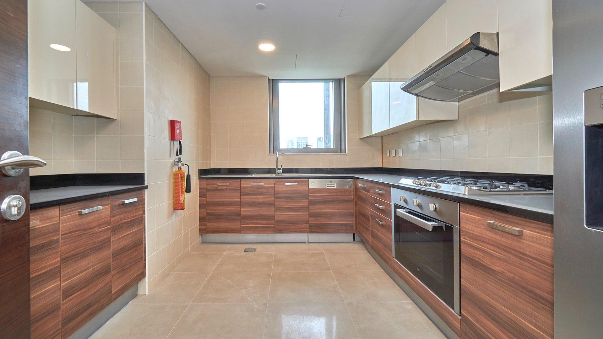 "Dubai Marina apartment balcony with stunning views of waterfront and skyline, Sparkle Towers.",Modern kitchen in Dubai Marina apartment, featuring sleek cabinetry and stainless steel appliances