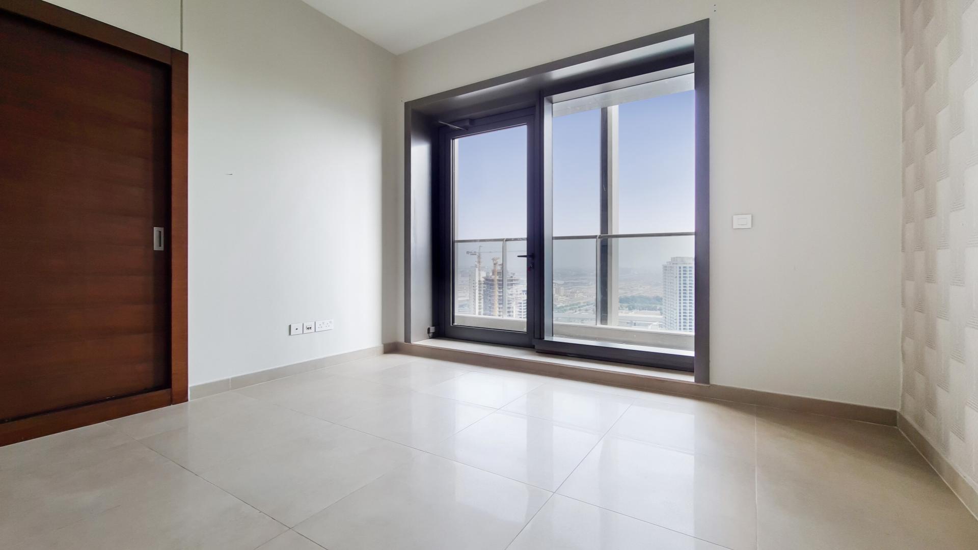 Empty room with large window and city views in Dubai Marina apartment, Sparkle Towers