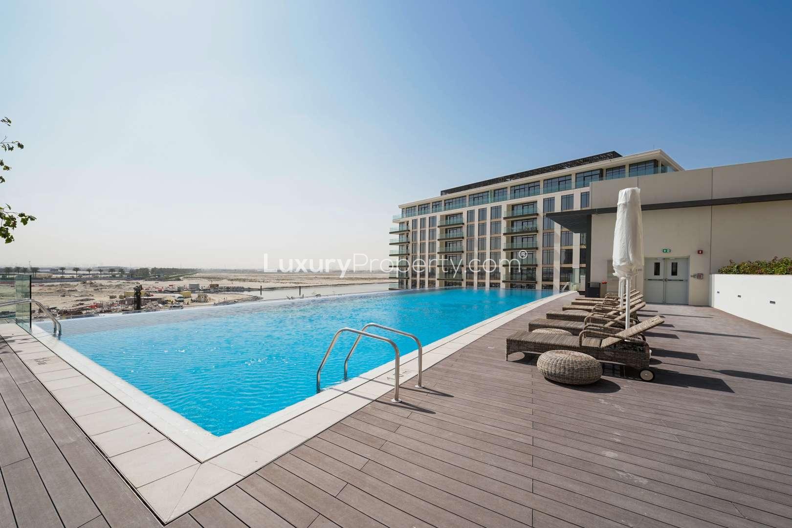 Rooftop pool with sun loungers at The Cove 3, Dubai Creek Harbour apartment complex